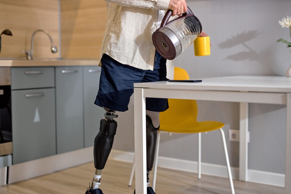 Man with prosthetic legs pouring drink